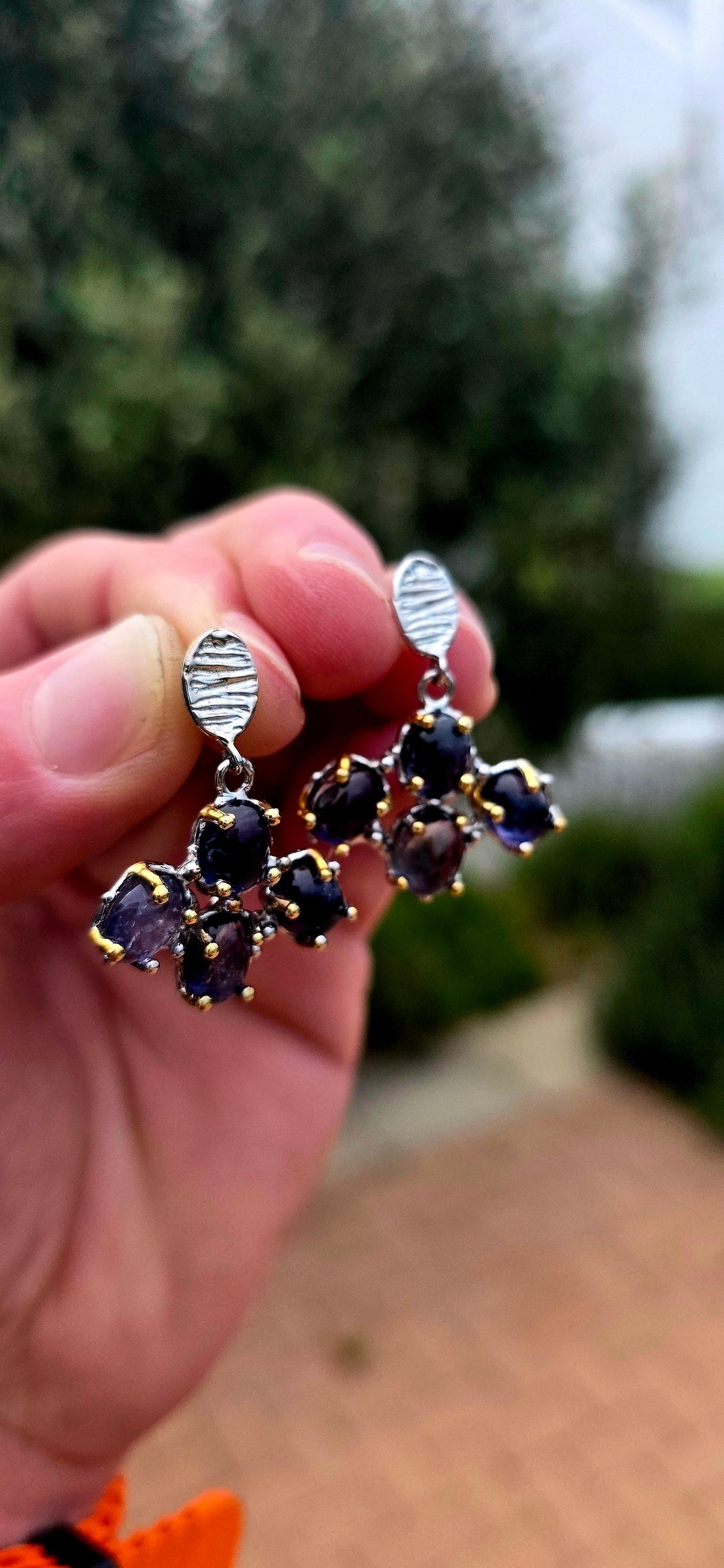 Handcrafted in sterling silver, these artisan drop earrings feature clusters of generously sized oval iolite cabochons, creating a beautifully organic floral formation beneath textured oval stud tops.