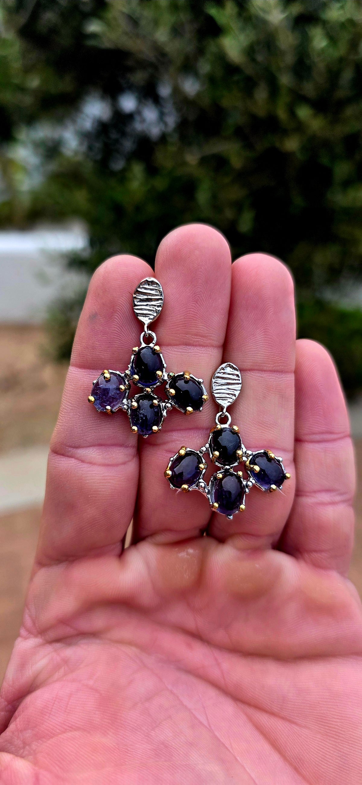 Handcrafted in sterling silver, these artisan drop earrings feature clusters of generously sized oval iolite cabochons, creating a beautifully organic floral formation beneath textured oval stud tops.