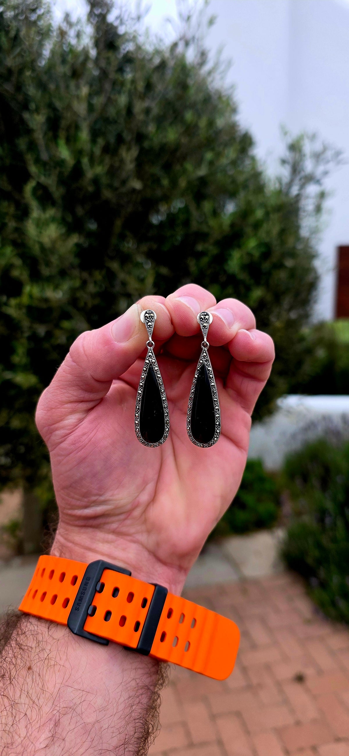 An incredibly elegant pair of Art Deco Revival sterling silver drop earrings, combining dramatic black onyx with the unmistakable sparkle of marcasite.