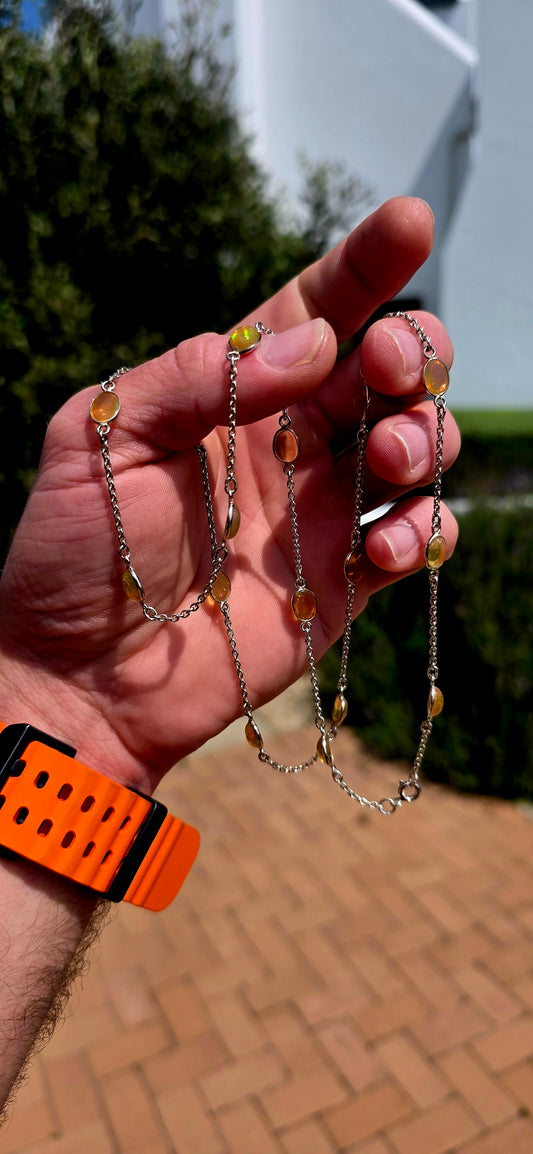 A gorgeous and elegant extra-length Sterling Silver station necklace, beautifully set with 16 oval translucent Ethiopian Welo Opal cabochons, individually bezel/tube set at intervals along the fine silver chain.