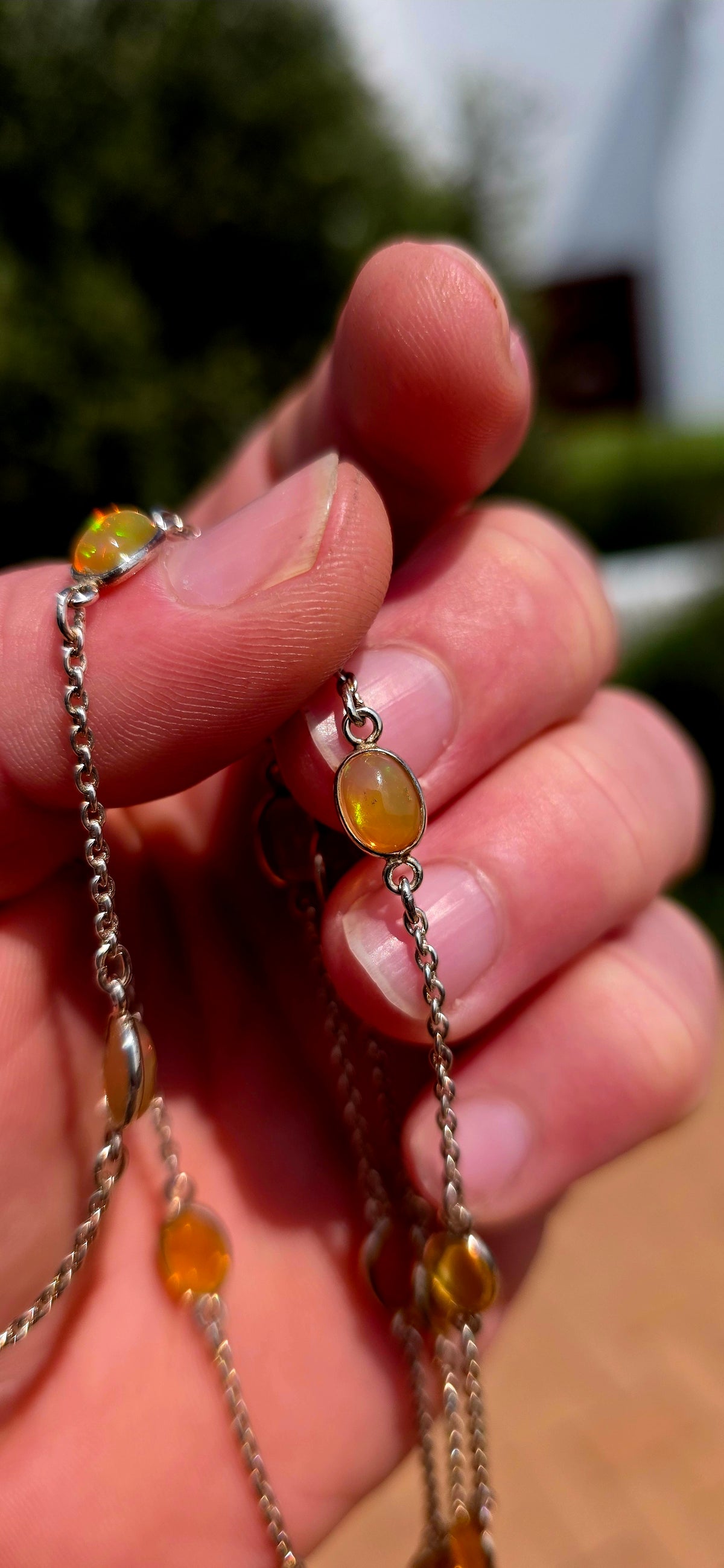 A gorgeous and elegant extra-length Sterling Silver station necklace, beautifully set with 16 oval translucent Ethiopian Welo Opal cabochons, individually bezel/tube set at intervals along the fine silver chain.