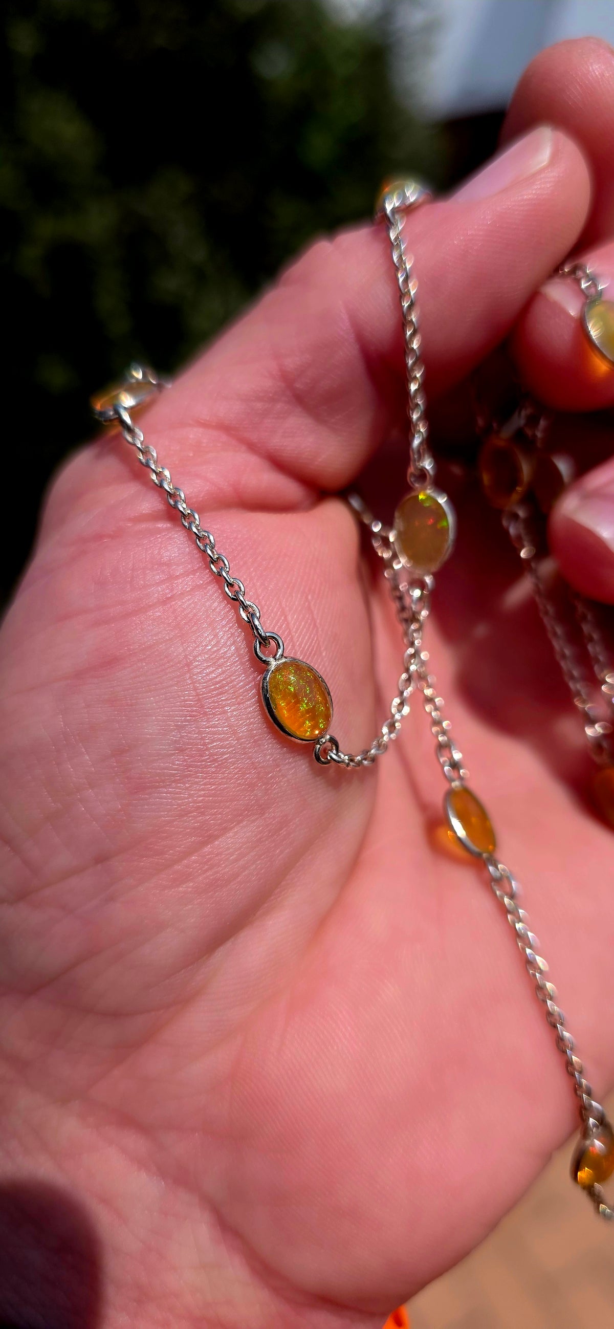 A gorgeous and elegant extra-length Sterling Silver station necklace, beautifully set with 16 oval translucent Ethiopian Welo Opal cabochons, individually bezel/tube set at intervals along the fine silver chain.