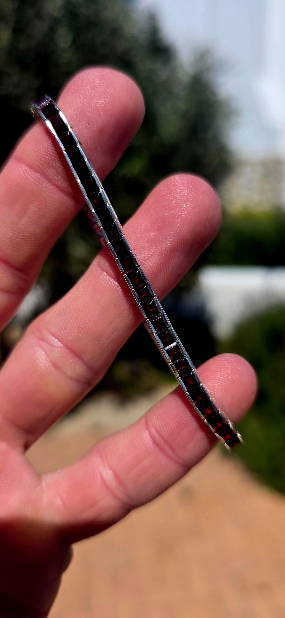 A wonderfully sleek vintage UNISEX sterling silver tennis bracelet, completely set with an impressive 56 deep-red garnets.