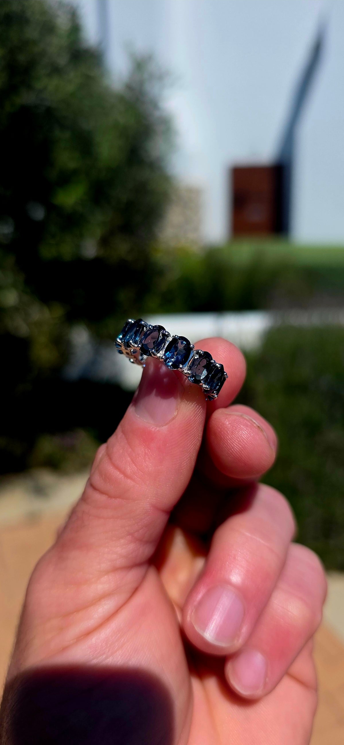 A gorgeous sterling silver full eternity stacking ring, set all the way around with 13 generously sized oval-cut London Blue Topaz gemstones.