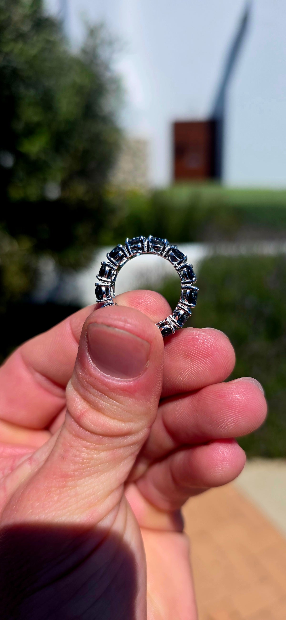 A gorgeous sterling silver full eternity stacking ring, set all the way around with 13 generously sized oval-cut London Blue Topaz gemstones.