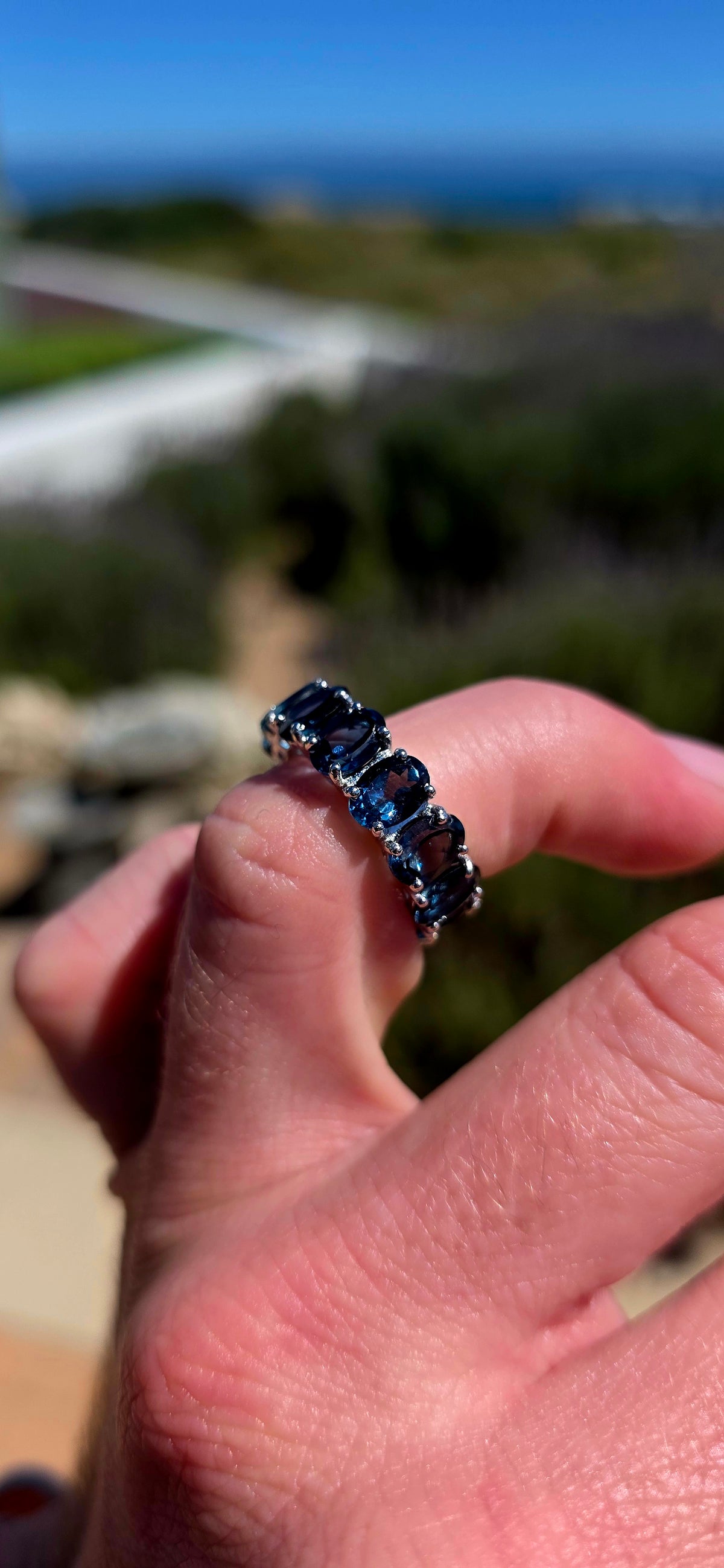 A gorgeous sterling silver full eternity stacking ring, set all the way around with 13 generously sized oval-cut London Blue Topaz gemstones.