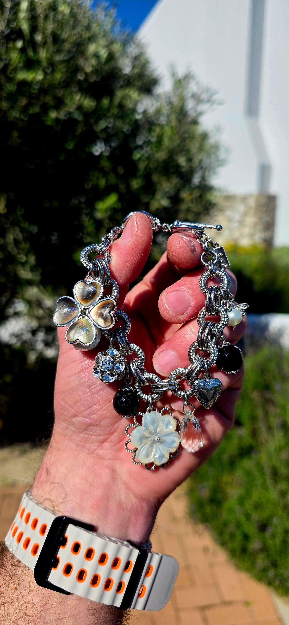 A fabulous high-quality designer costume charm bracelet by Fifth Avenue Collection, crafted in beautifully substantial silver rhodium-plated metal with an incredible mix of textures and sparkle.