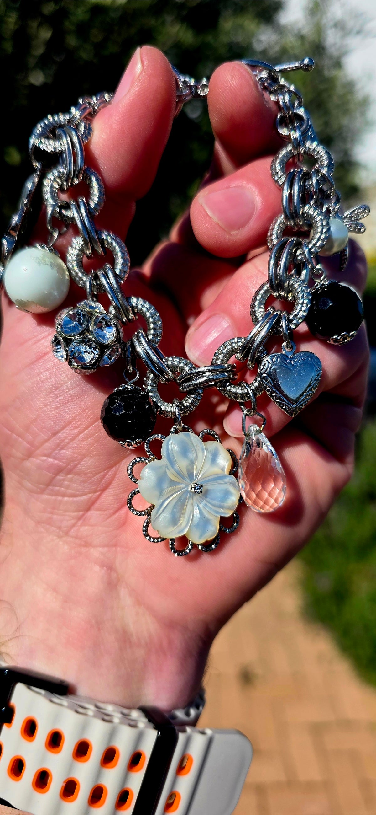 A fabulous high-quality designer costume charm bracelet by Fifth Avenue Collection, crafted in beautifully substantial silver rhodium-plated metal with an incredible mix of textures and sparkle.
