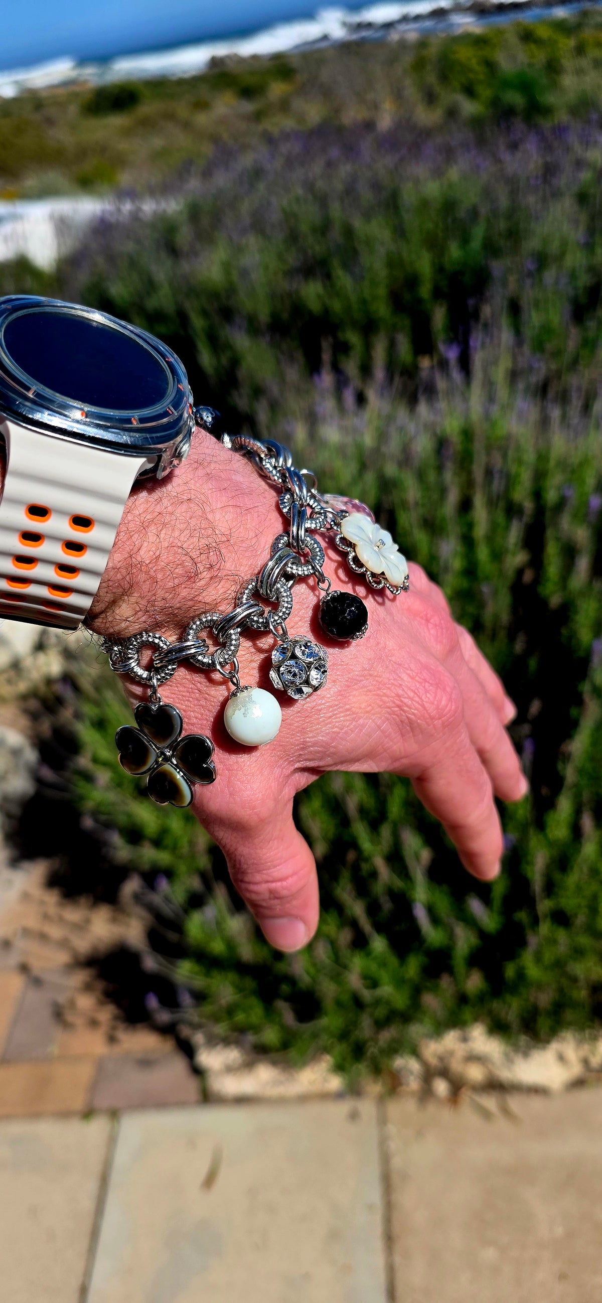A fabulous high-quality designer costume charm bracelet by Fifth Avenue Collection, crafted in beautifully substantial silver rhodium-plated metal with an incredible mix of textures and sparkle.