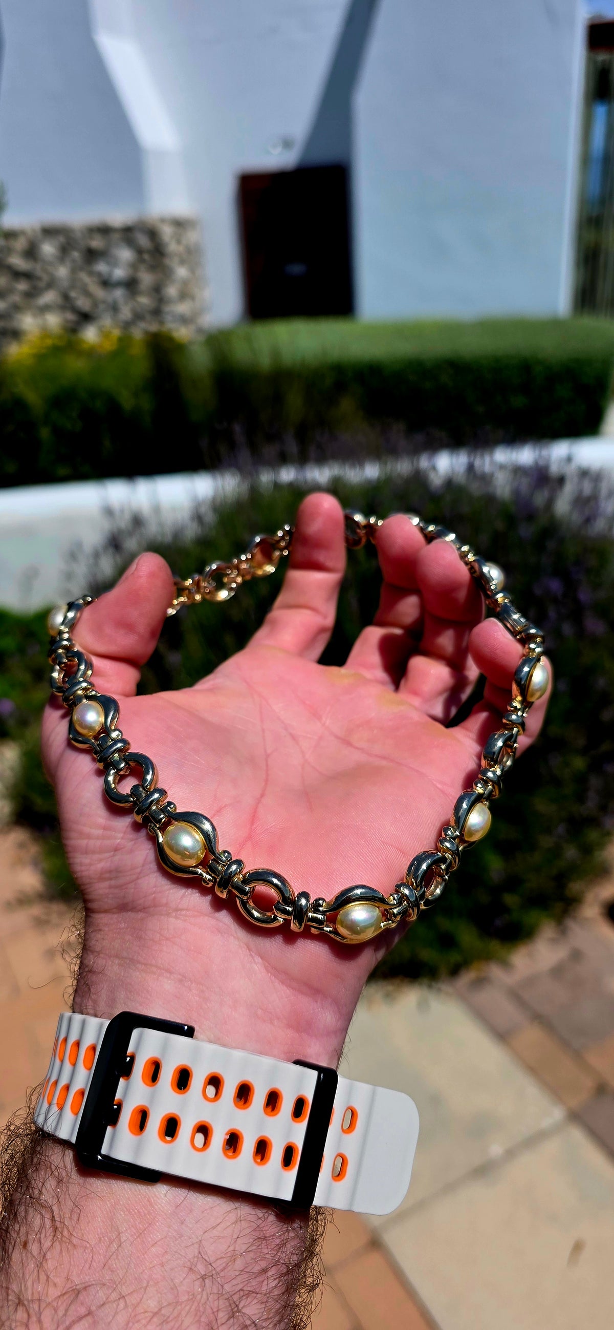 A gorgeous vintage 1990s costume necklace combining bold yellow gold-plated metalwork with beautifully lustrous oval faux pearl cabochons.