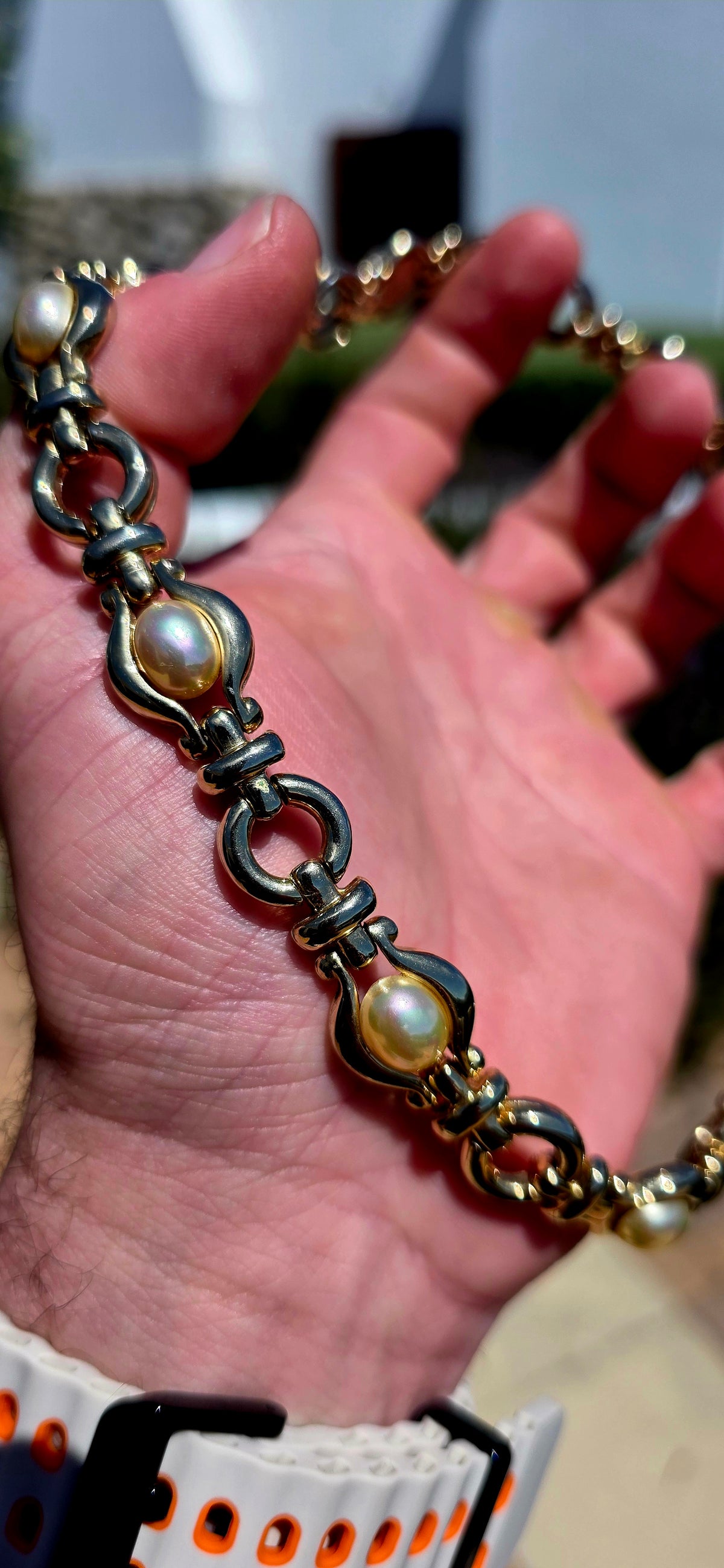 A gorgeous vintage 1990s costume necklace combining bold yellow gold-plated metalwork with beautifully lustrous oval faux pearl cabochons.