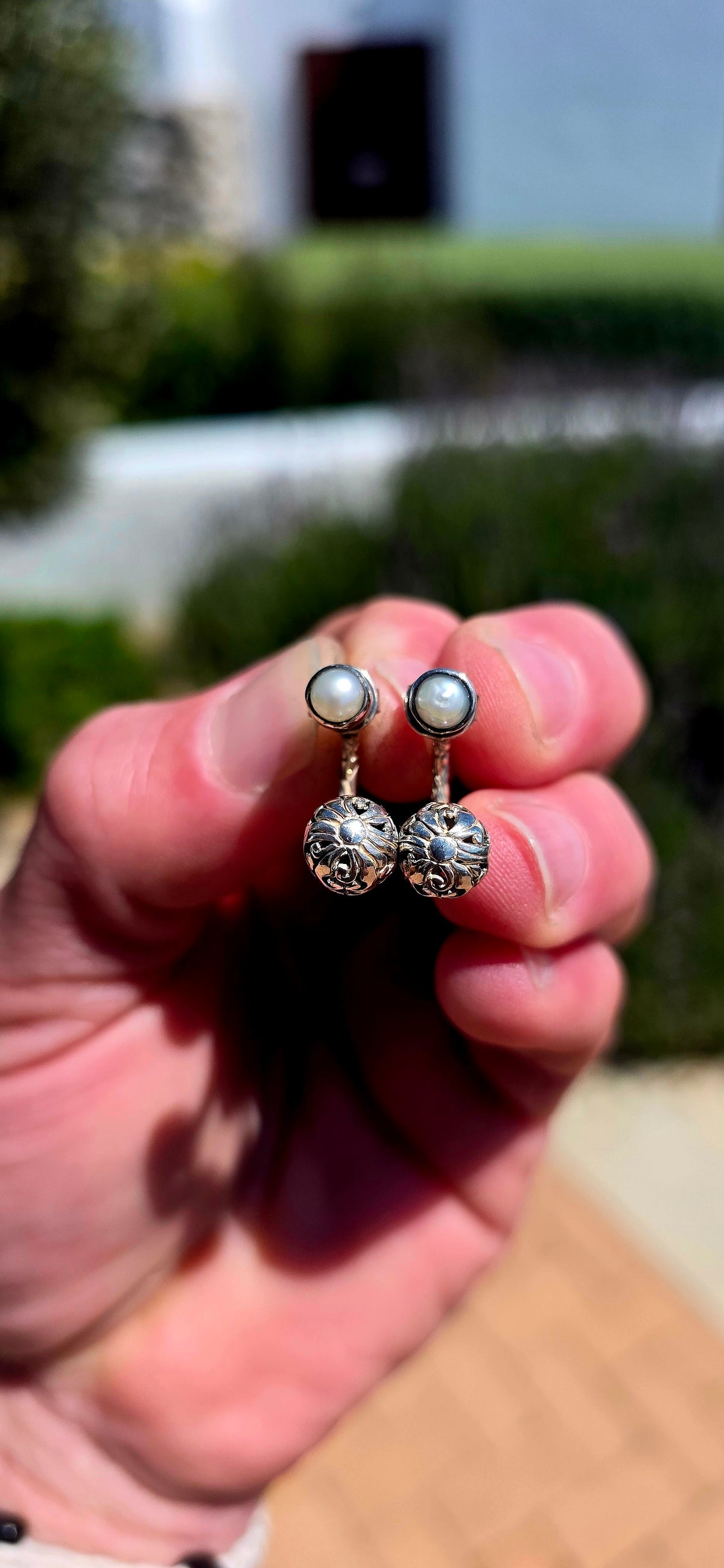 A wonderfully versatile pair of sterling silver earrings combining classical pearl elegance with beautifully detailed silver craftsmanship!