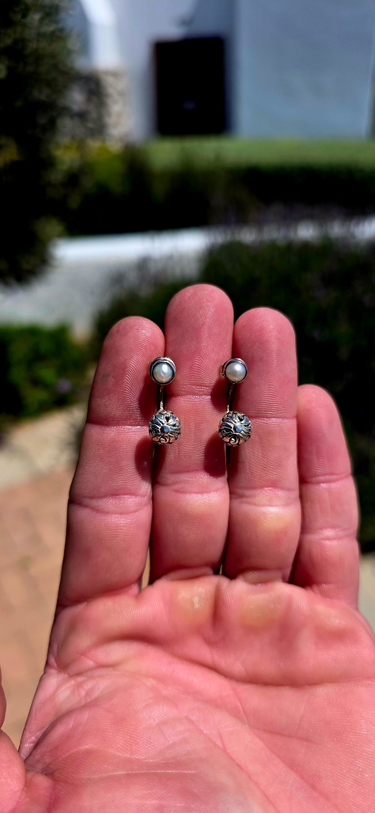 A wonderfully versatile pair of sterling silver earrings combining classical pearl elegance with beautifully detailed silver craftsmanship!