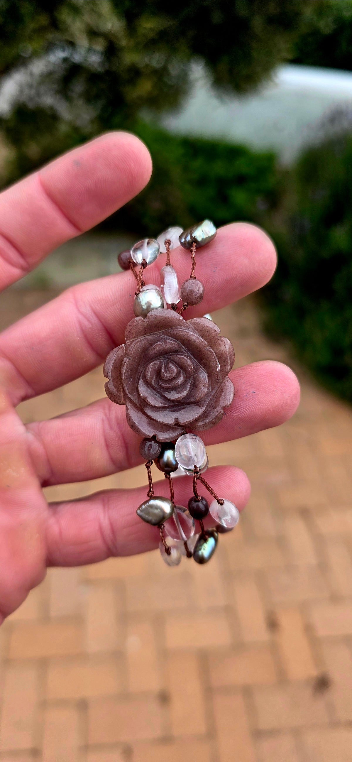 A gorgeous artisan-made four-strand macramé bracelet, featuring a beautifully carved strawberry quartz gemstone rose as its magnificent centrepiece!