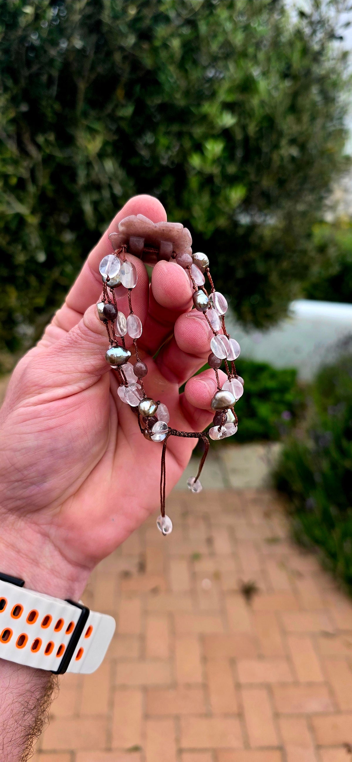 A gorgeous artisan-made four-strand macramé bracelet, featuring a beautifully carved strawberry quartz gemstone rose as its magnificent centrepiece!