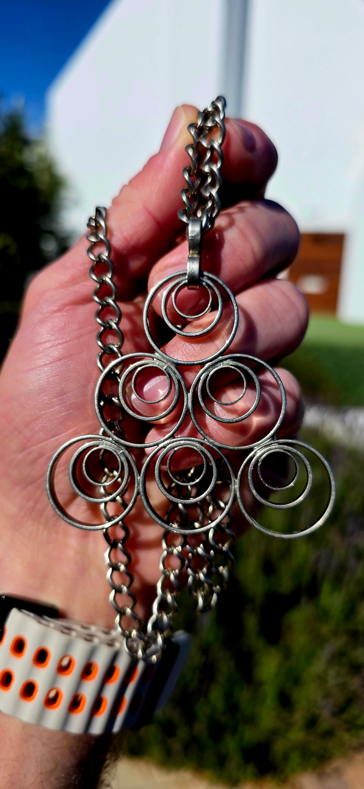 A striking vintage modernist studio-made necklace, featuring a generously sized, sculptural silvertone pendant suspended from an extra-length chain!