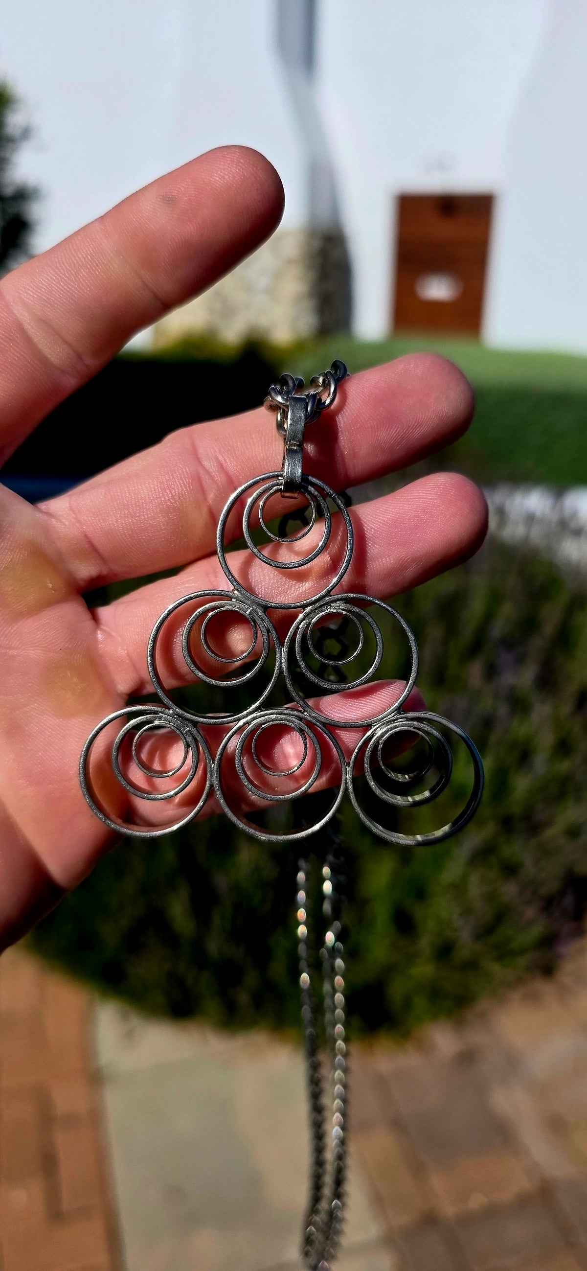 A striking vintage modernist studio-made necklace, featuring a generously sized, sculptural silvertone pendant suspended from an extra-length chain!