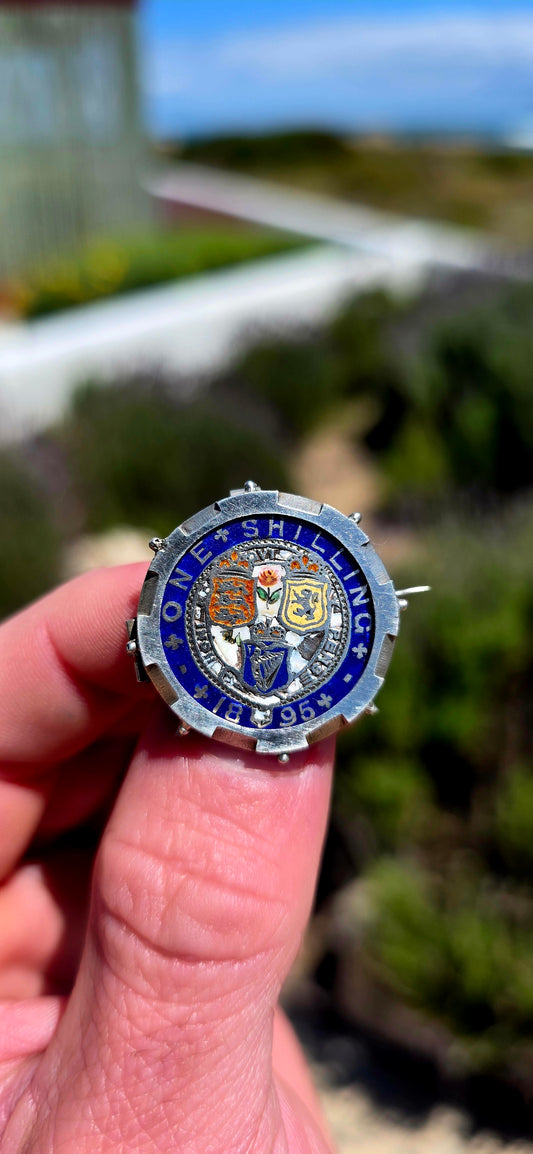 A beautiful antique sweetheart brooch featuring a genuine 1895 British sterling silver One Shilling coin, wonderfully decorated with colourful enamel!