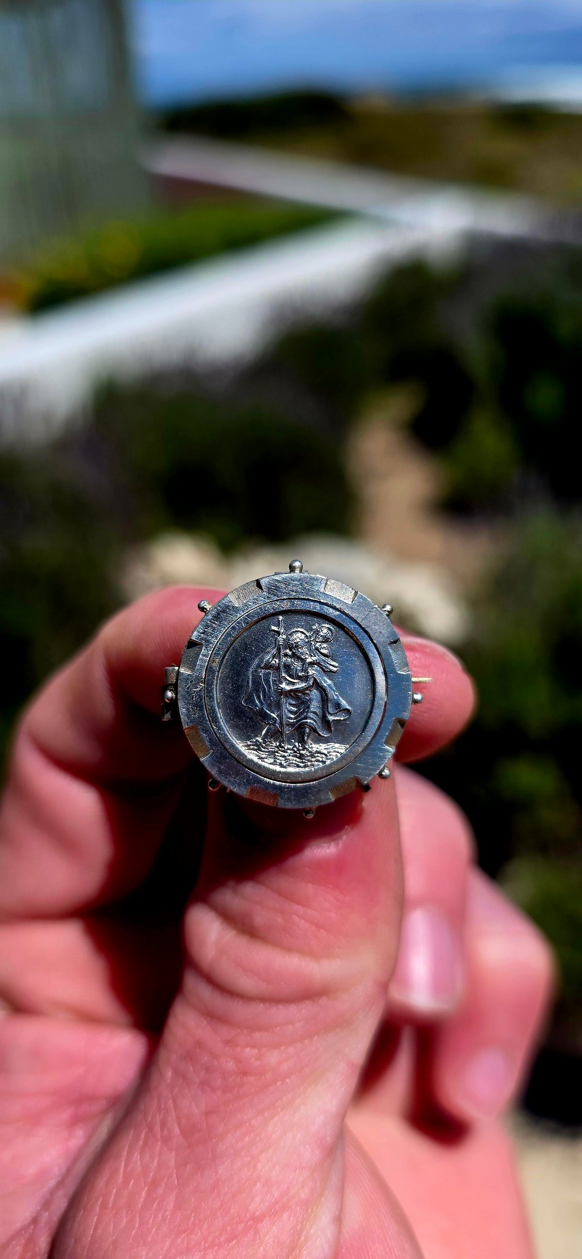 A lovely antique sterling silver brooch featuring a circular St Christopher devotional medallion, beautifully detailed with a raised depiction of the beloved patron saint of travellers.