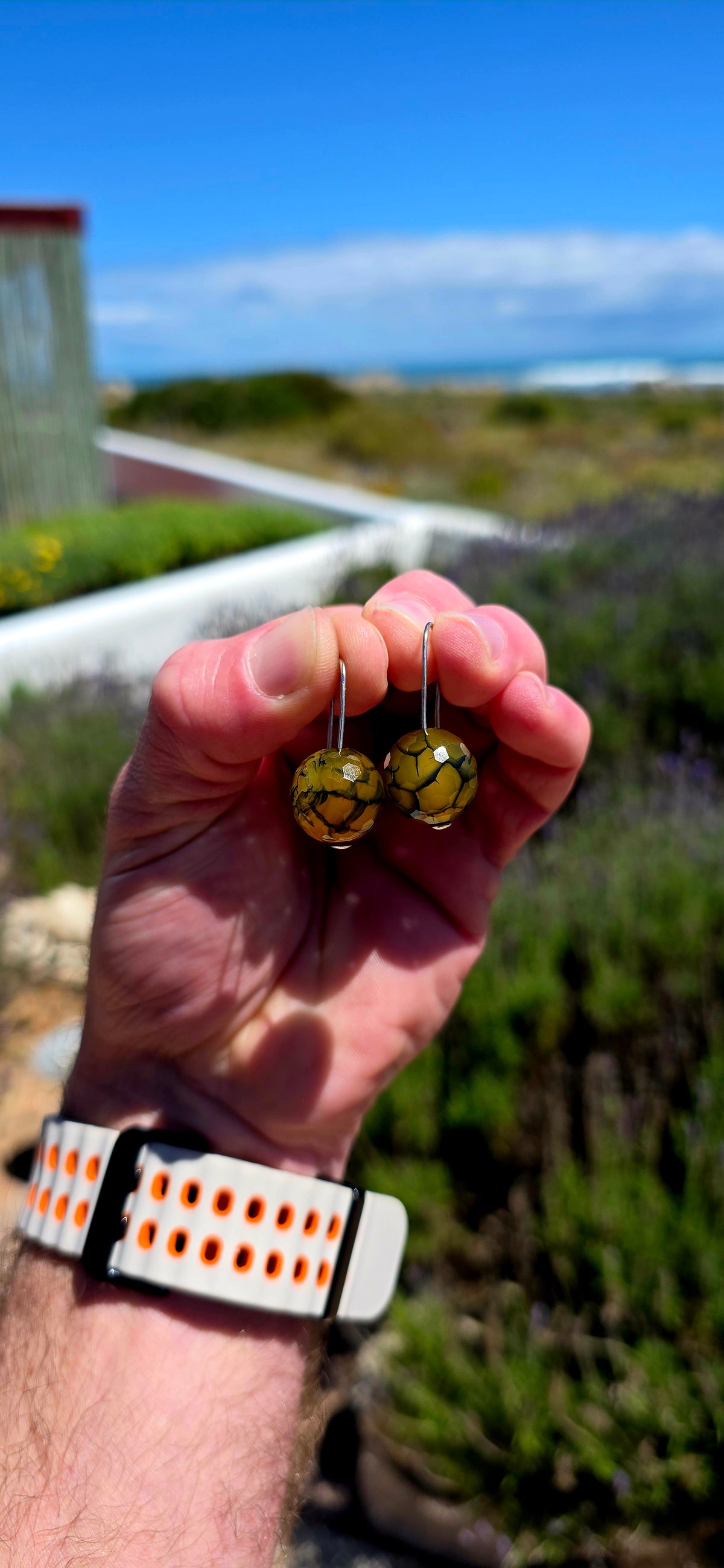 A gorgeous pair of artisan-crafted sterling silver earrings featuring beautifully faceted Dragon Vein Agate gemstone orbs!