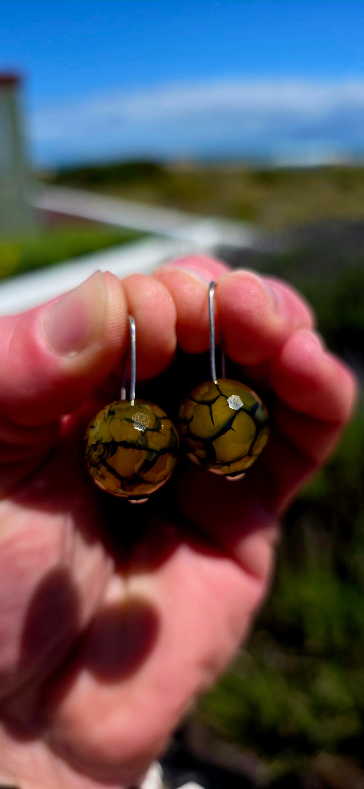 A gorgeous pair of artisan-crafted sterling silver earrings featuring beautifully faceted Dragon Vein Agate gemstone orbs!