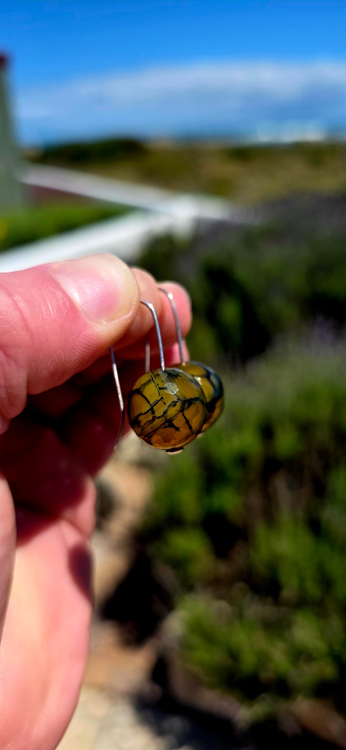 A gorgeous pair of artisan-crafted sterling silver earrings featuring beautifully faceted Dragon Vein Agate gemstone orbs!