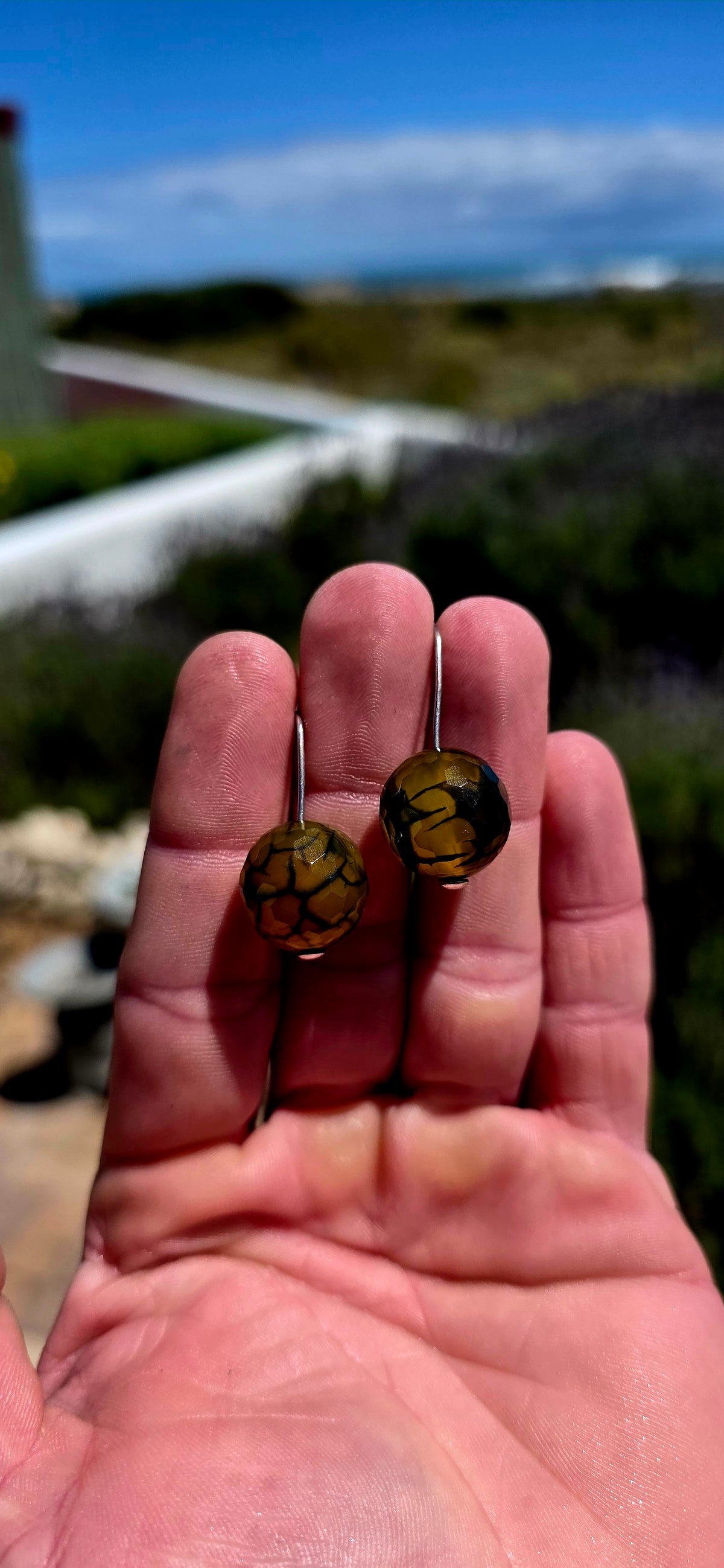 A gorgeous pair of artisan-crafted sterling silver earrings featuring beautifully faceted Dragon Vein Agate gemstone orbs!