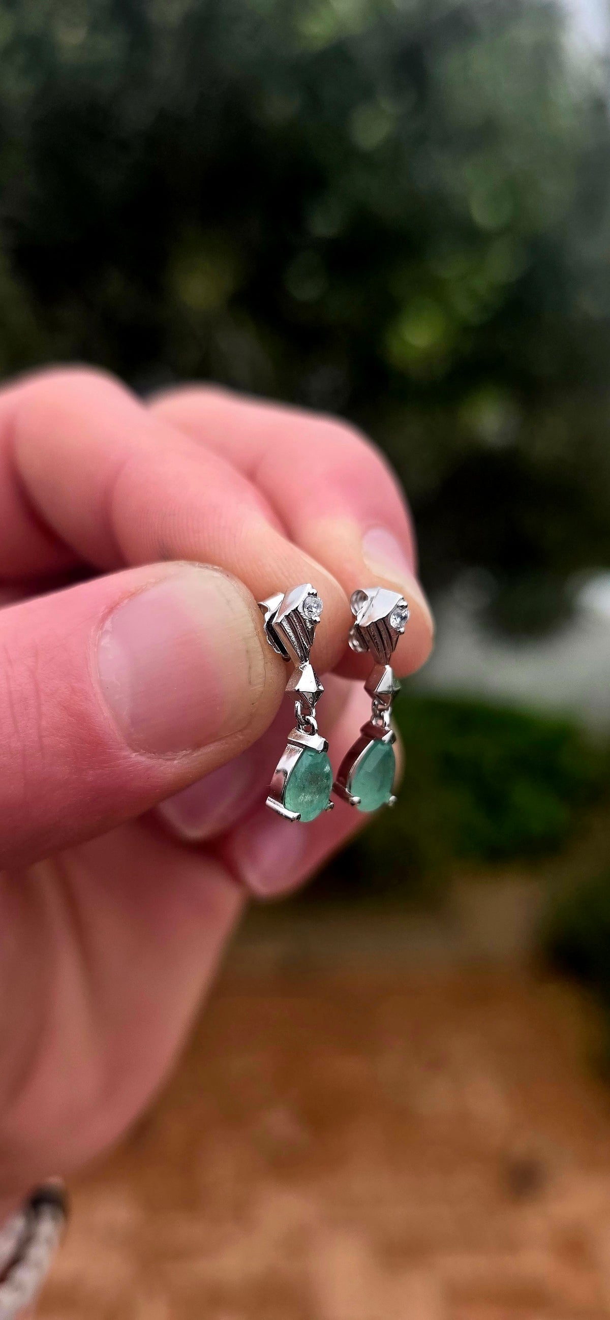 A beautiful pair of sterling silver drop earrings combining the enchanting green of emeralds with the delicate sparkle of white topaz!