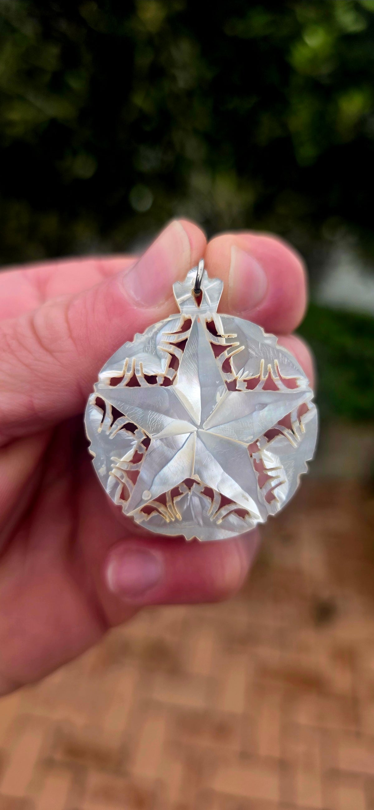 A beautiful vintage hand-carved mother-of-pearl pendant, featuring a magnificent five-pointed star surrounded by delicate openwork detailing!