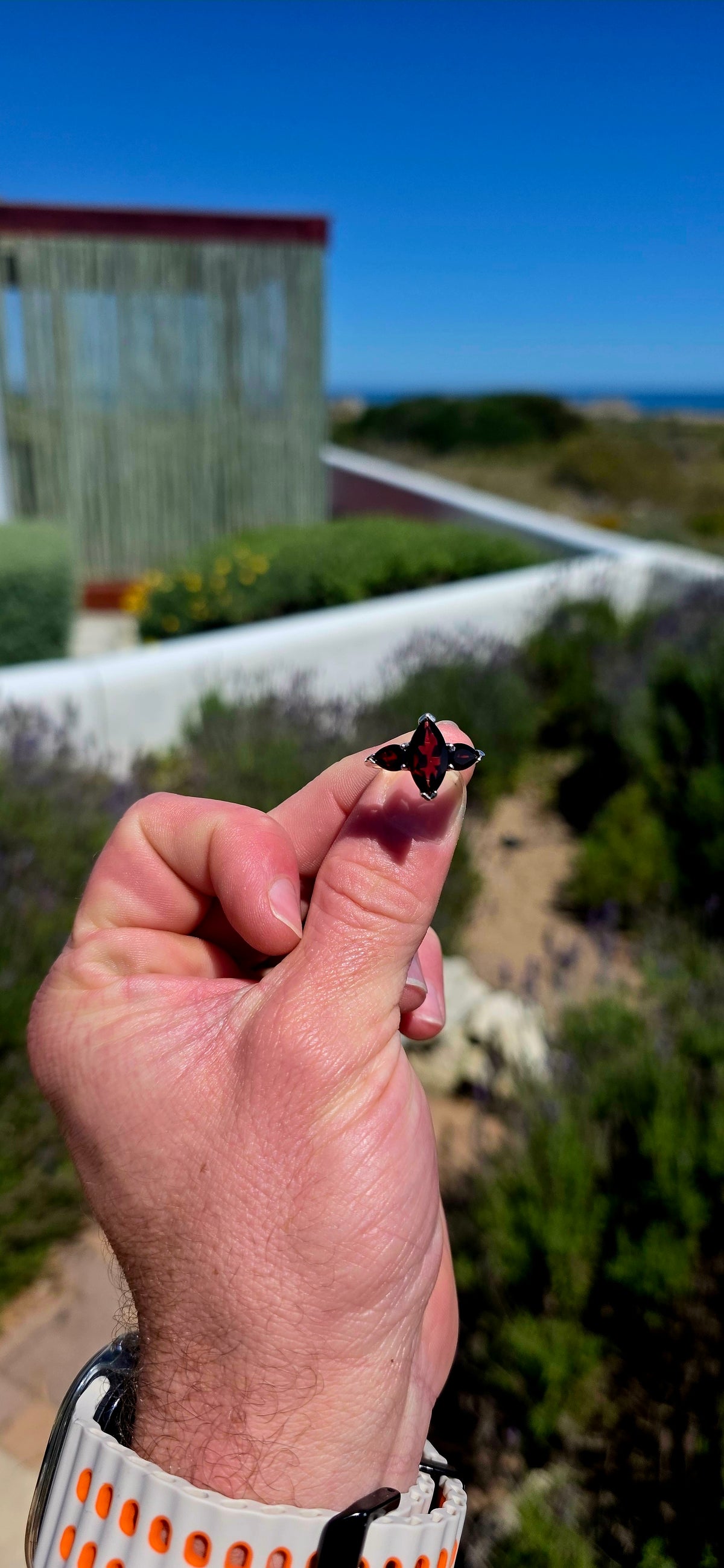 A gorgeous sterling silver trilogy ring featuring three beautifully faceted, deep wine-red garnets in a wonderfully elegant and slightly dramatic design!