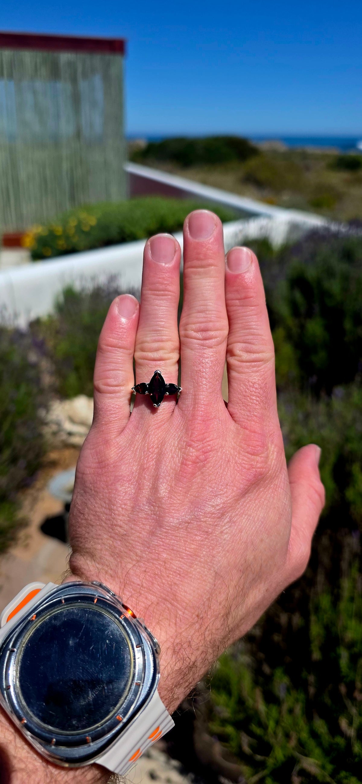 A gorgeous sterling silver trilogy ring featuring three beautifully faceted, deep wine-red garnets in a wonderfully elegant and slightly dramatic design!