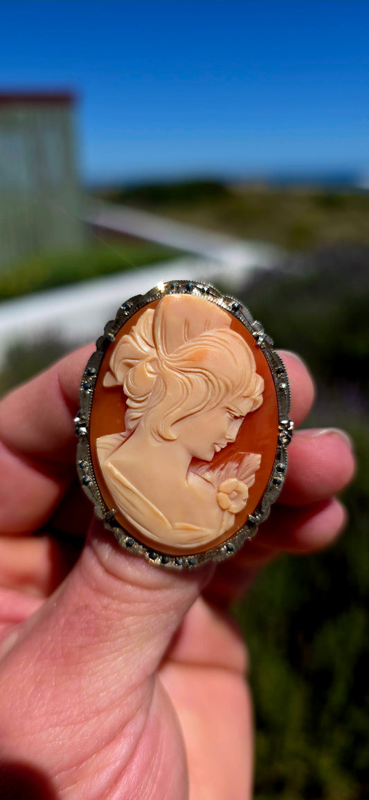 A generously sized vintage circa 1940s Art Deco-era cameo brooch / pendant, beautifully hand-carved from natural conch shell and mounted in an elegant sterling silver frame adorned with sparkling marcasites!