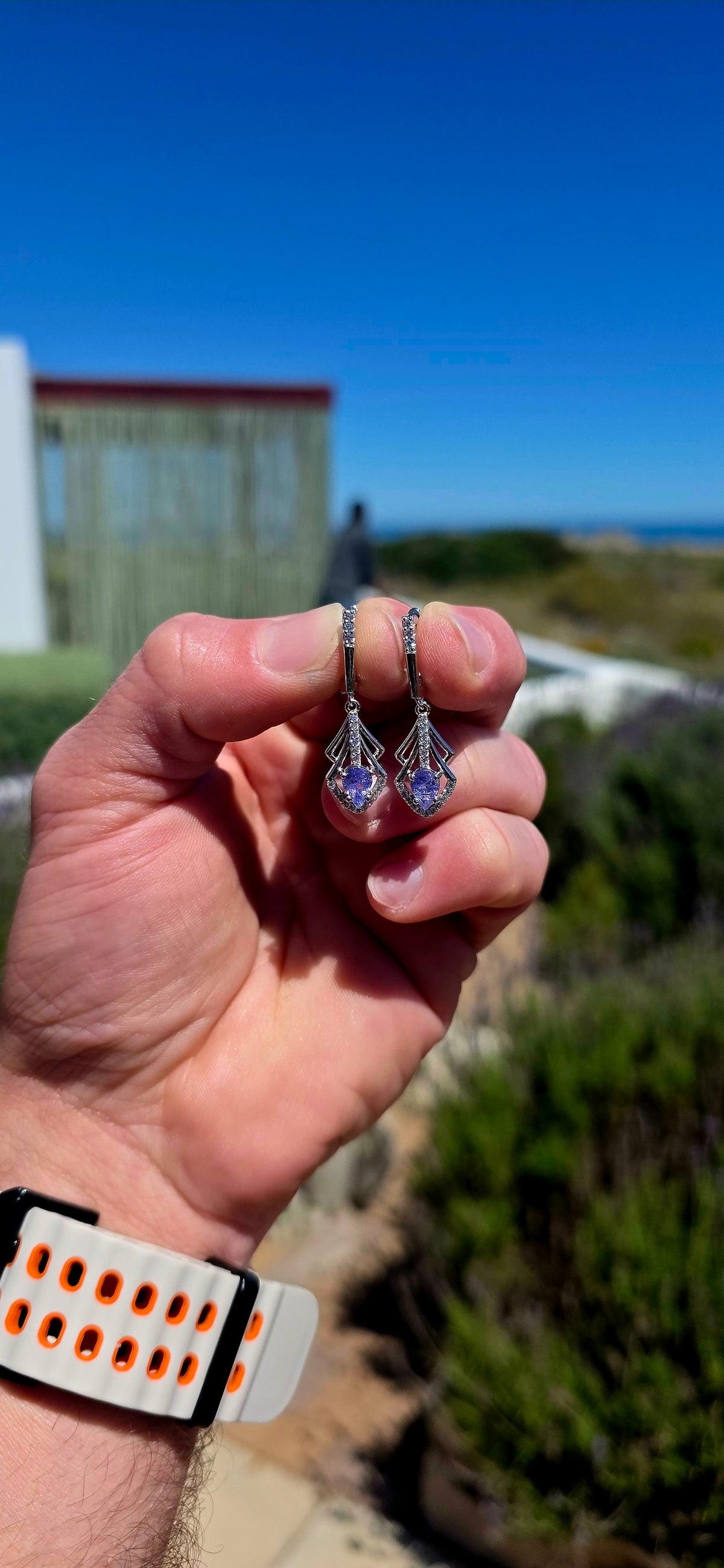 A beautifully elegant pair of Art Deco revival sterling silver drop earrings, featuring enchanting violet-blue tanzanites complemented by sparkling cubic zirconia gemstones!