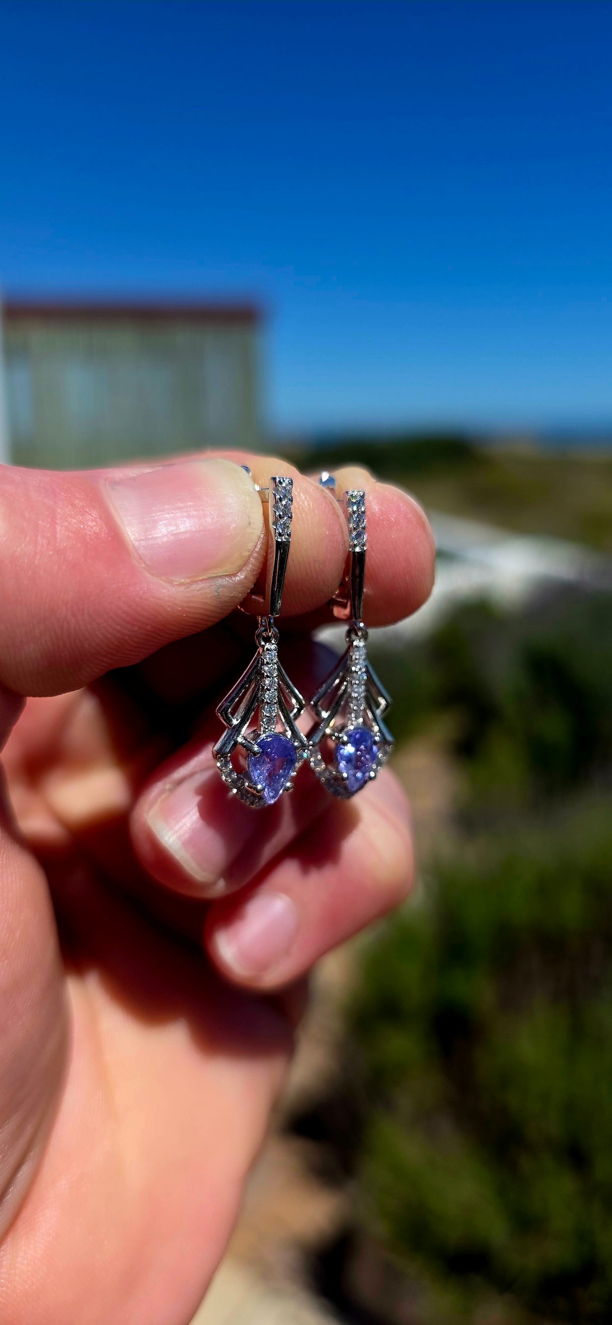 A beautifully elegant pair of Art Deco revival sterling silver drop earrings, featuring enchanting violet-blue tanzanites complemented by sparkling cubic zirconia gemstones!