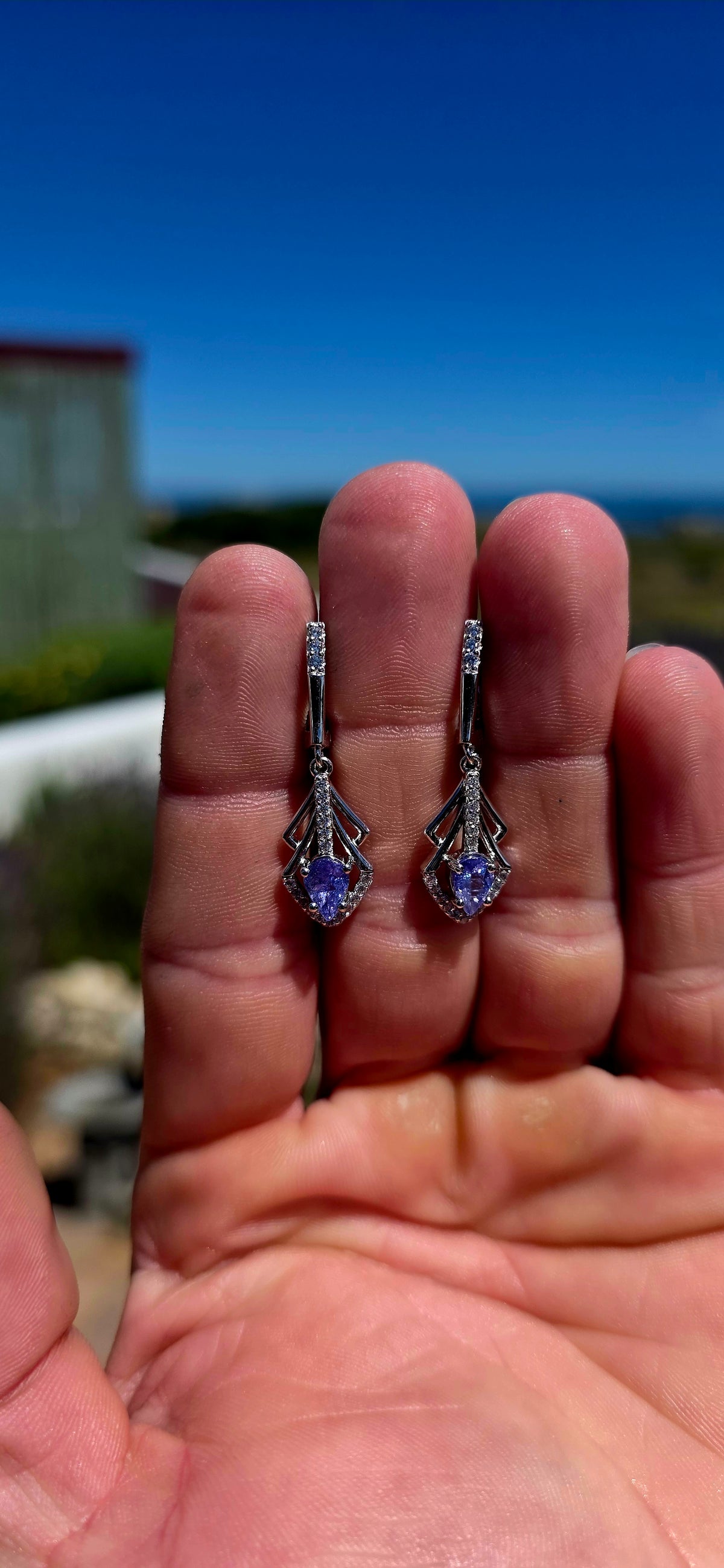 A beautifully elegant pair of Art Deco revival sterling silver drop earrings, featuring enchanting violet-blue tanzanites complemented by sparkling cubic zirconia gemstones!