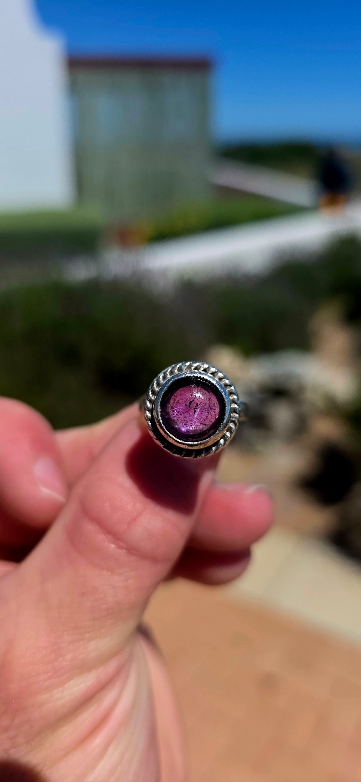 A striking handcrafted Kabwe sterling silver statement ring featuring a gorgeous, rounded purple amethyst cabochon, beautifully elevated within an elaborate sculptural silver setting.