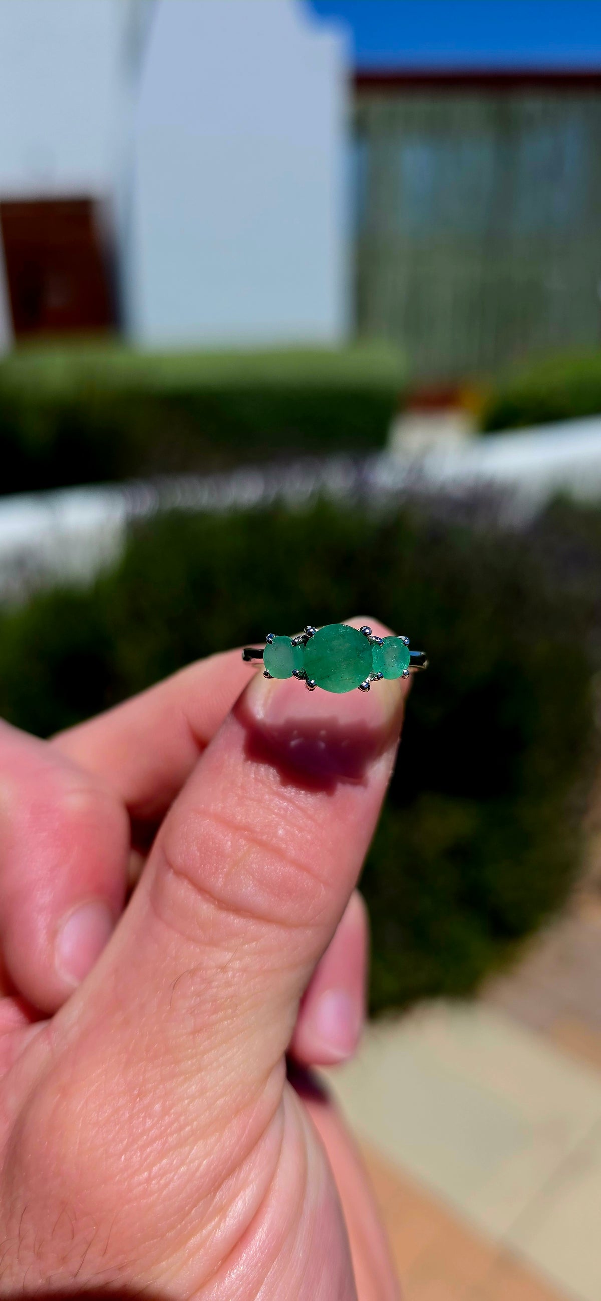 A wonderfully elegant sterling silver and emerald trilogy ring, featuring three gorgeous round-cut emerald gemstones in the most enchanting shades of green!