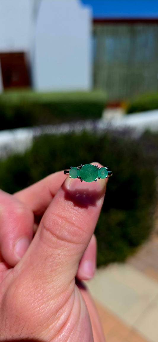 A wonderfully elegant sterling silver and emerald trilogy ring, featuring three gorgeous round-cut emerald gemstones in the most enchanting shades of green!