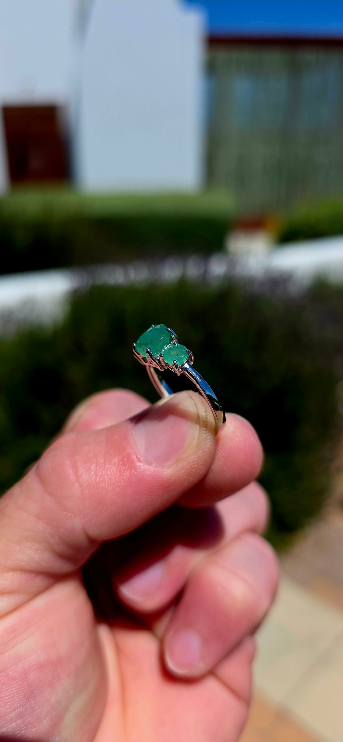 A wonderfully elegant sterling silver and emerald trilogy ring, featuring three gorgeous round-cut emerald gemstones in the most enchanting shades of green!