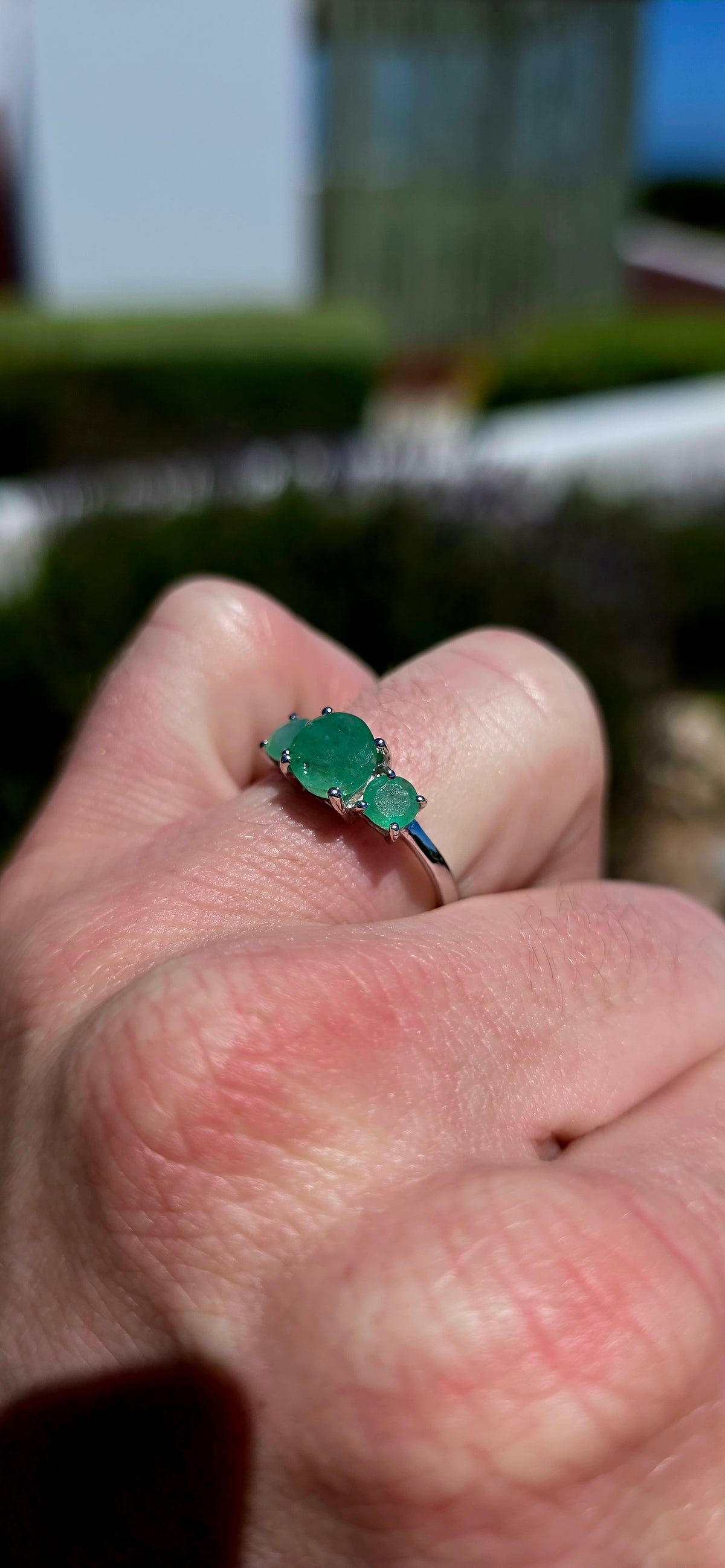 A wonderfully elegant sterling silver and emerald trilogy ring, featuring three gorgeous round-cut emerald gemstones in the most enchanting shades of green!