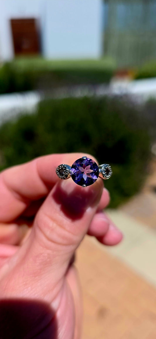 A magnificent vintage-inspired sterling silver dress ring, featuring a generously sized, sparkling round-cut purple amethyst taking centre stage!