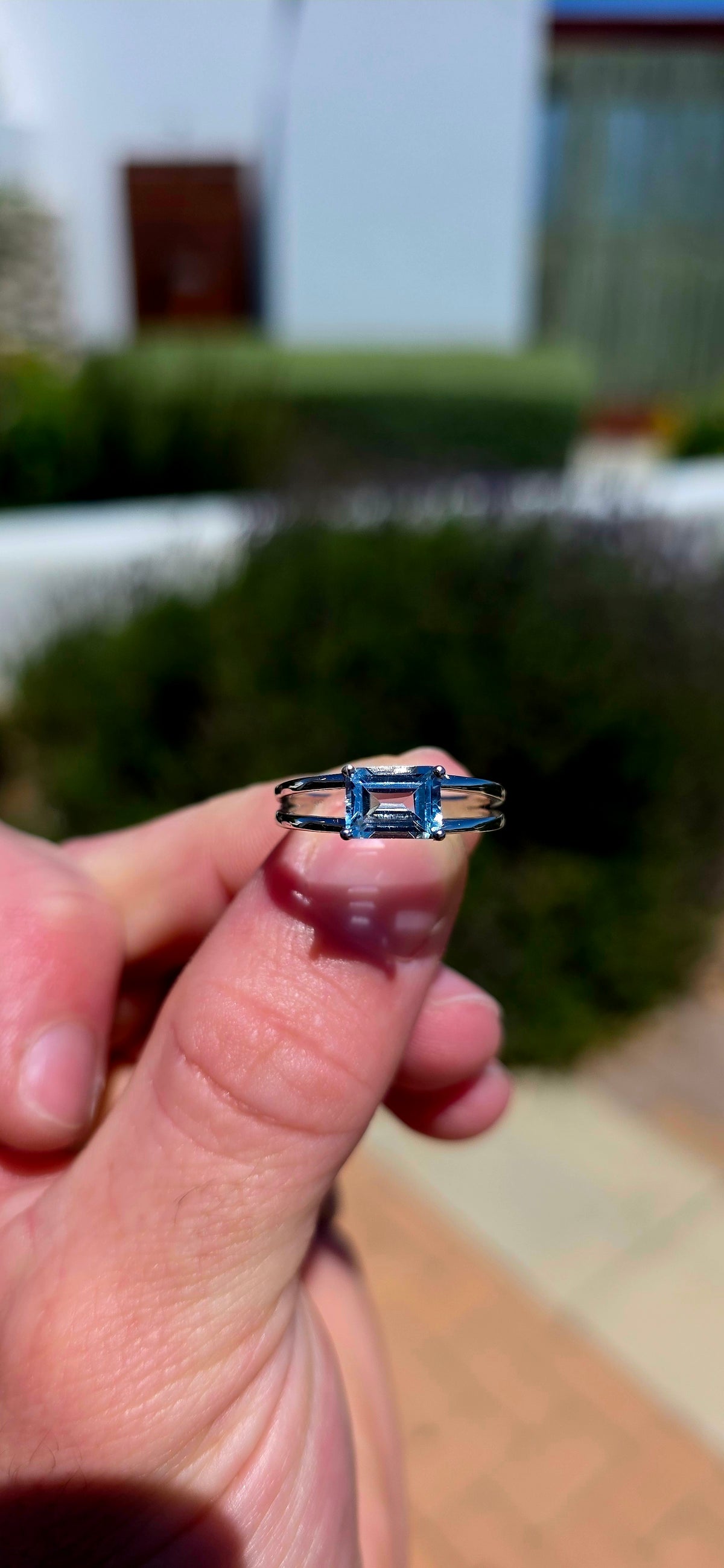 A wonderfully elegant sterling silver solitaire ring featuring a gorgeous emerald-cut sky blue topaz, beautifully showcased in a delicate, contemporary setting!